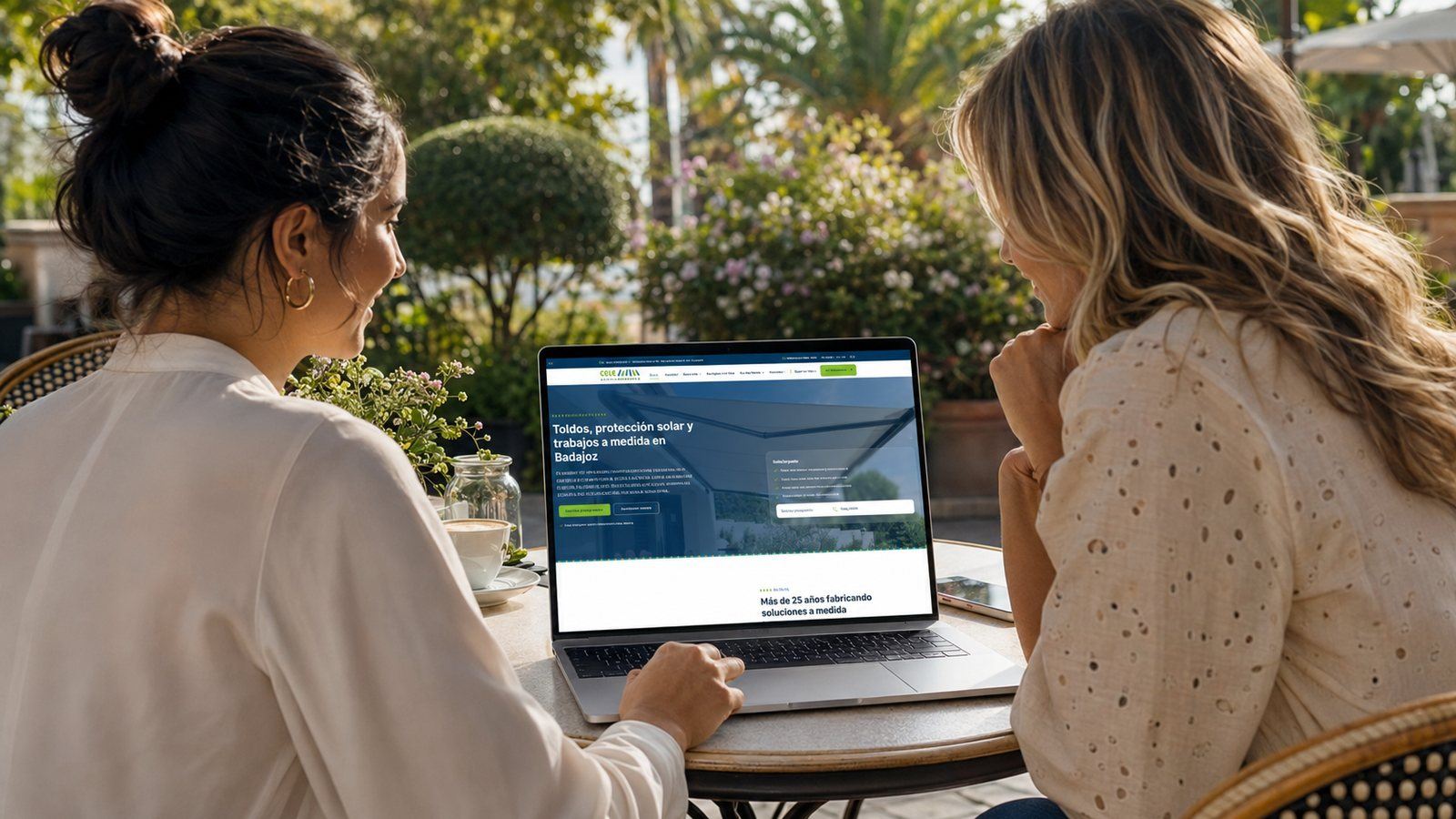 Creada con IA: dos mujeres ficticias consultando en un portátil la web de Toldos Cele en un jardín